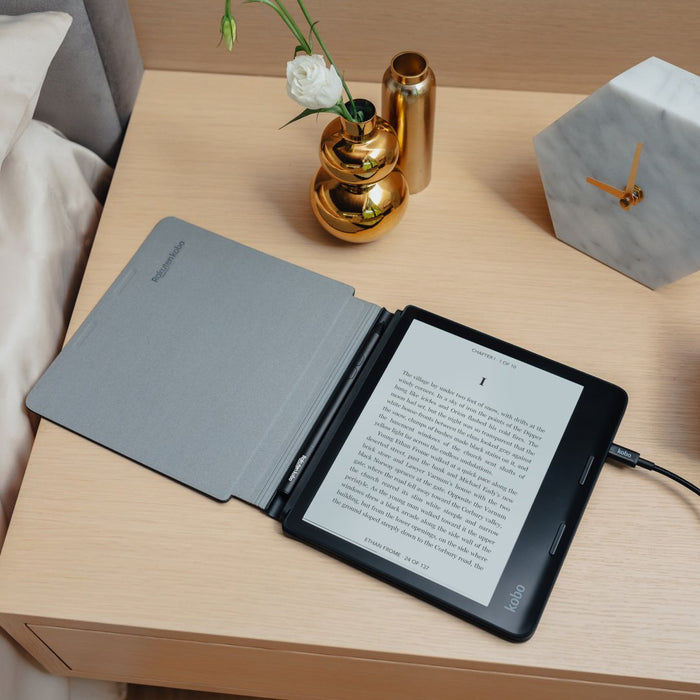 Kobo Sage in an opened Kobo Sage powercover, charging on a nightstand.